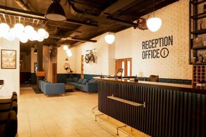 A reception area with a counter, seating, and a wall with a sign reading 'RECEPTION OFFICE'.