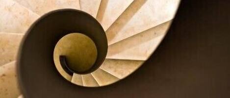 A spiral staircase with a central column and steps radiating outward.