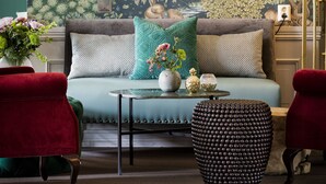 A living room with a sofa, two armchairs, a coffee table, and a patterned rug. - Fågelbro Säteri (Fågelbrolandet)
