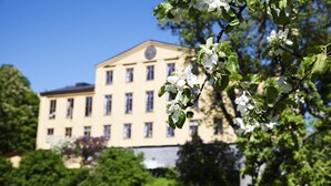 Un grand bâtiment de style classique, doté de nombreuses fenêtres et d’une horloge centrale.