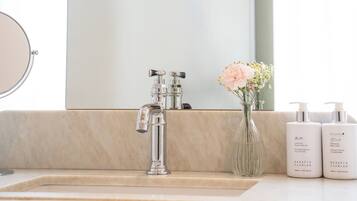 Un baño con un tocador moderno, ducha y espejo.