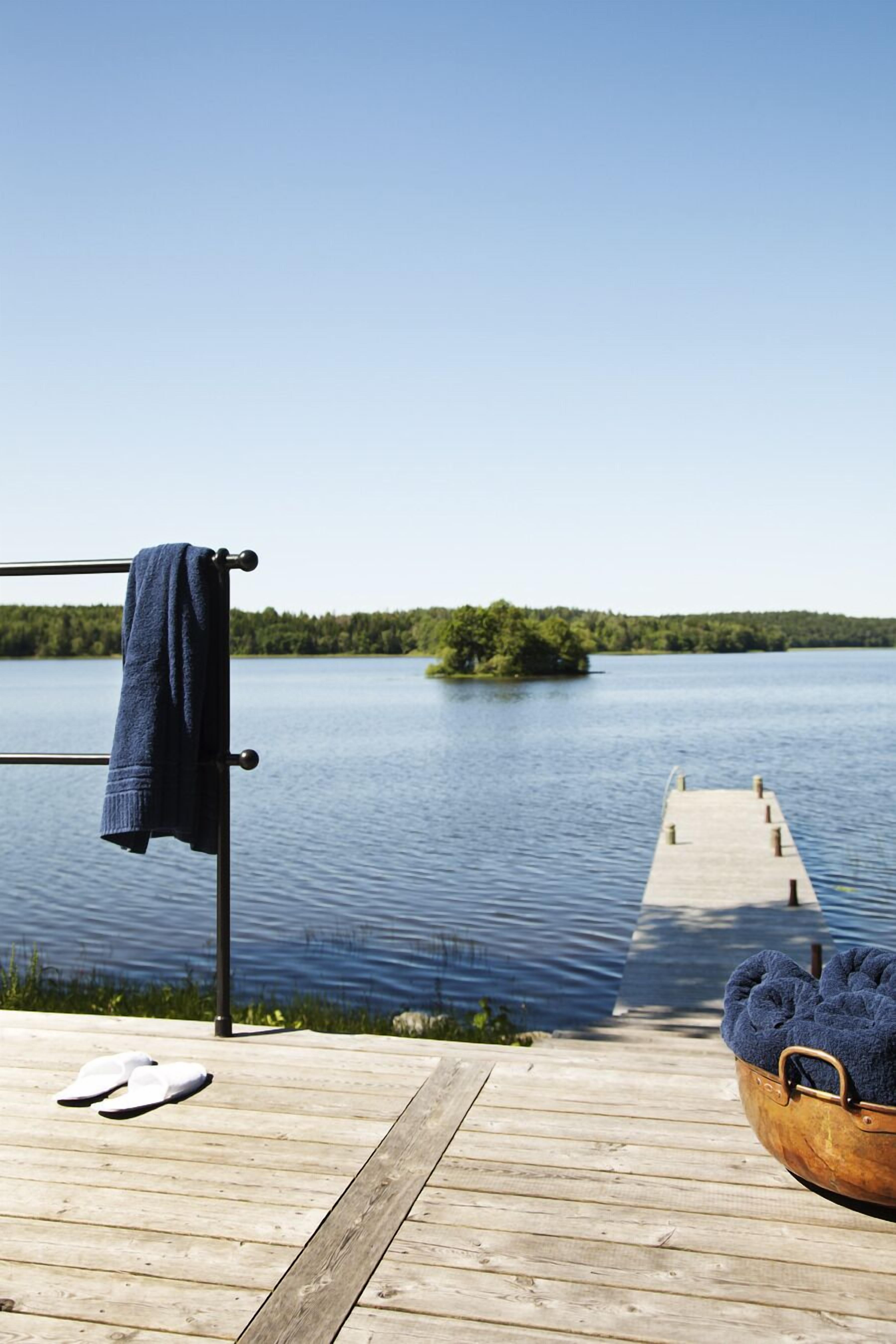 A wooden dock extending into a calm lake with a clear sky.