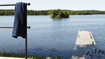 A wooden dock extending into a calm lake with a clear sky.