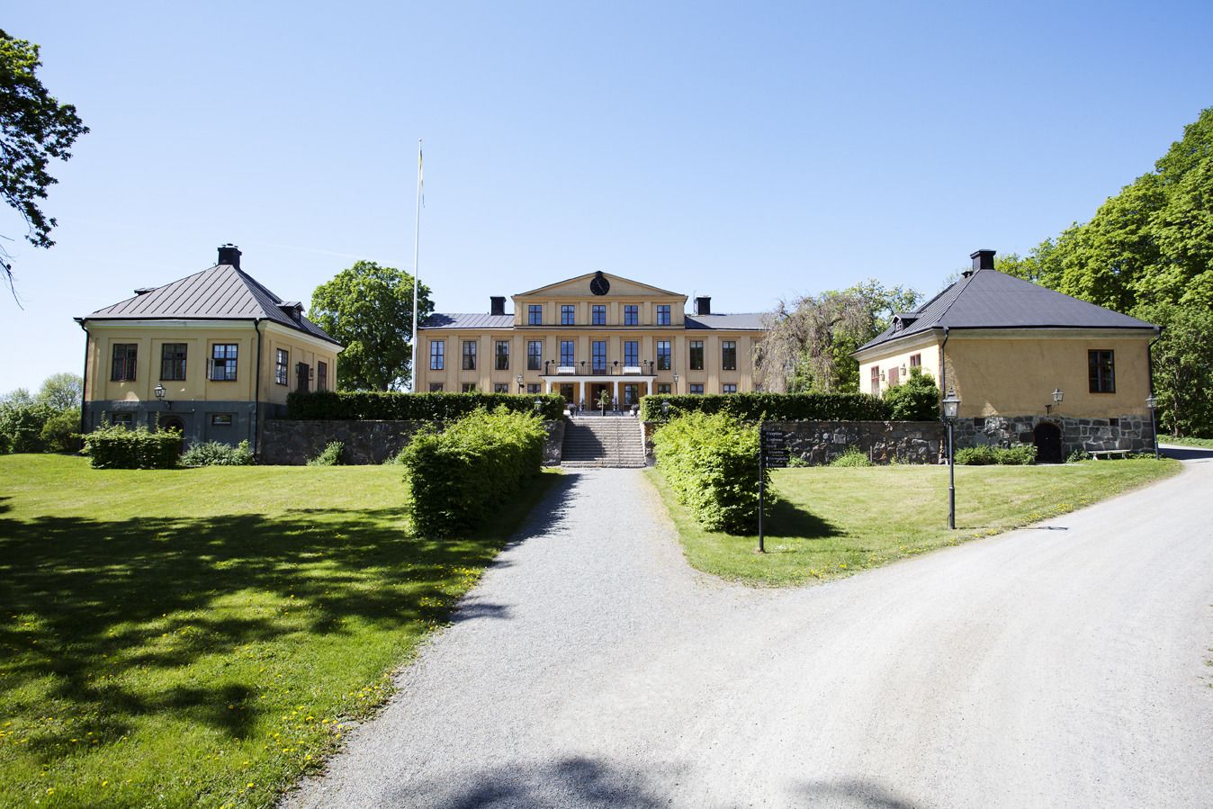 A large, symmetrical building with a central entrance, flanked by two smaller structures.