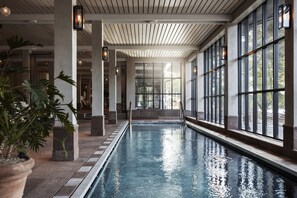 An indoor swimming pool with clear glass walls, a tiled floor, and a wooden ceiling. - Smådalarö Gård (Dalaro)