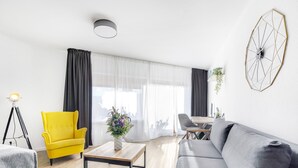 Una sala de estar moderna con un sillón amarillo, un sofá gris y una mesa de centro de madera.