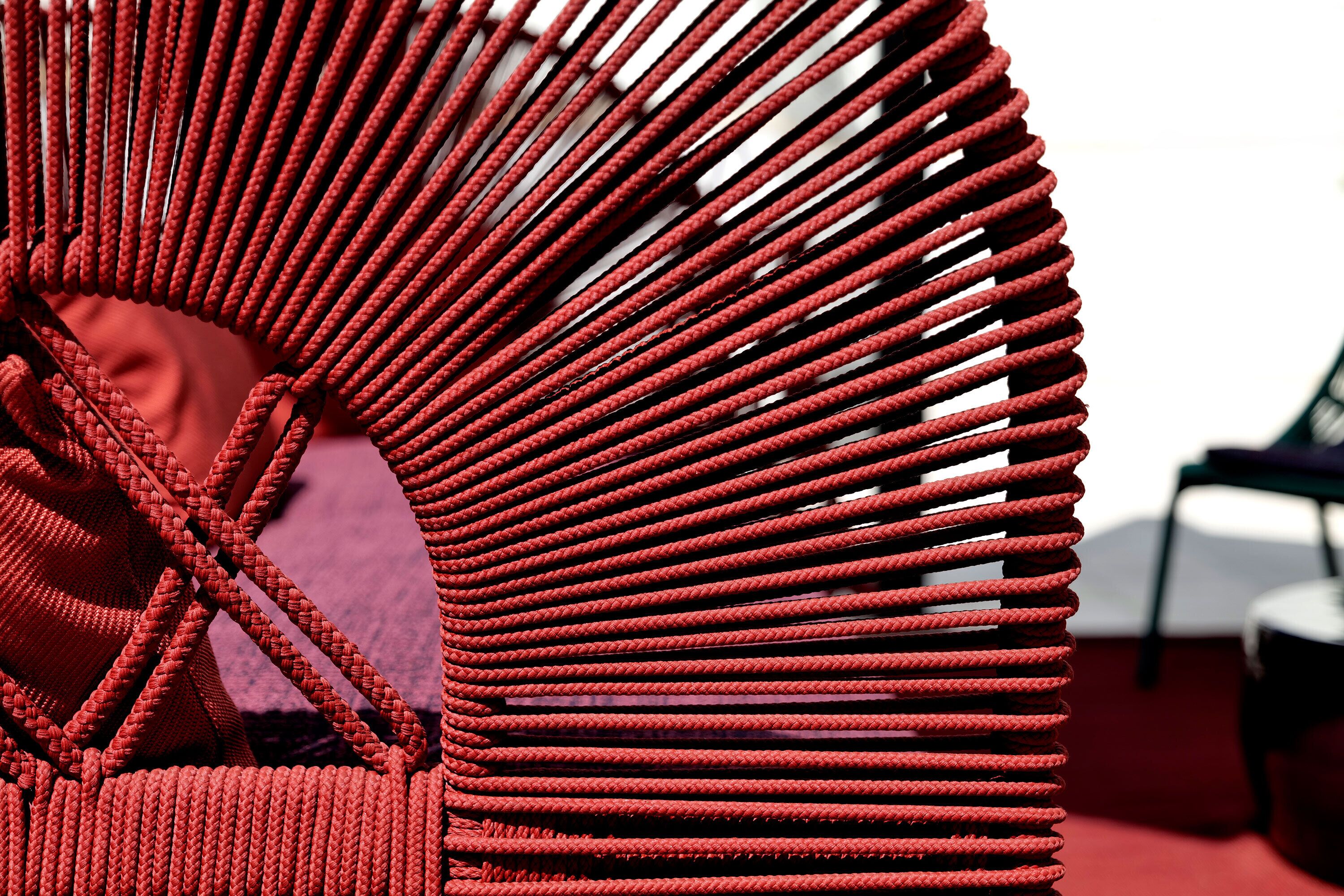 A close-up of a red woven chair with a circular design.
