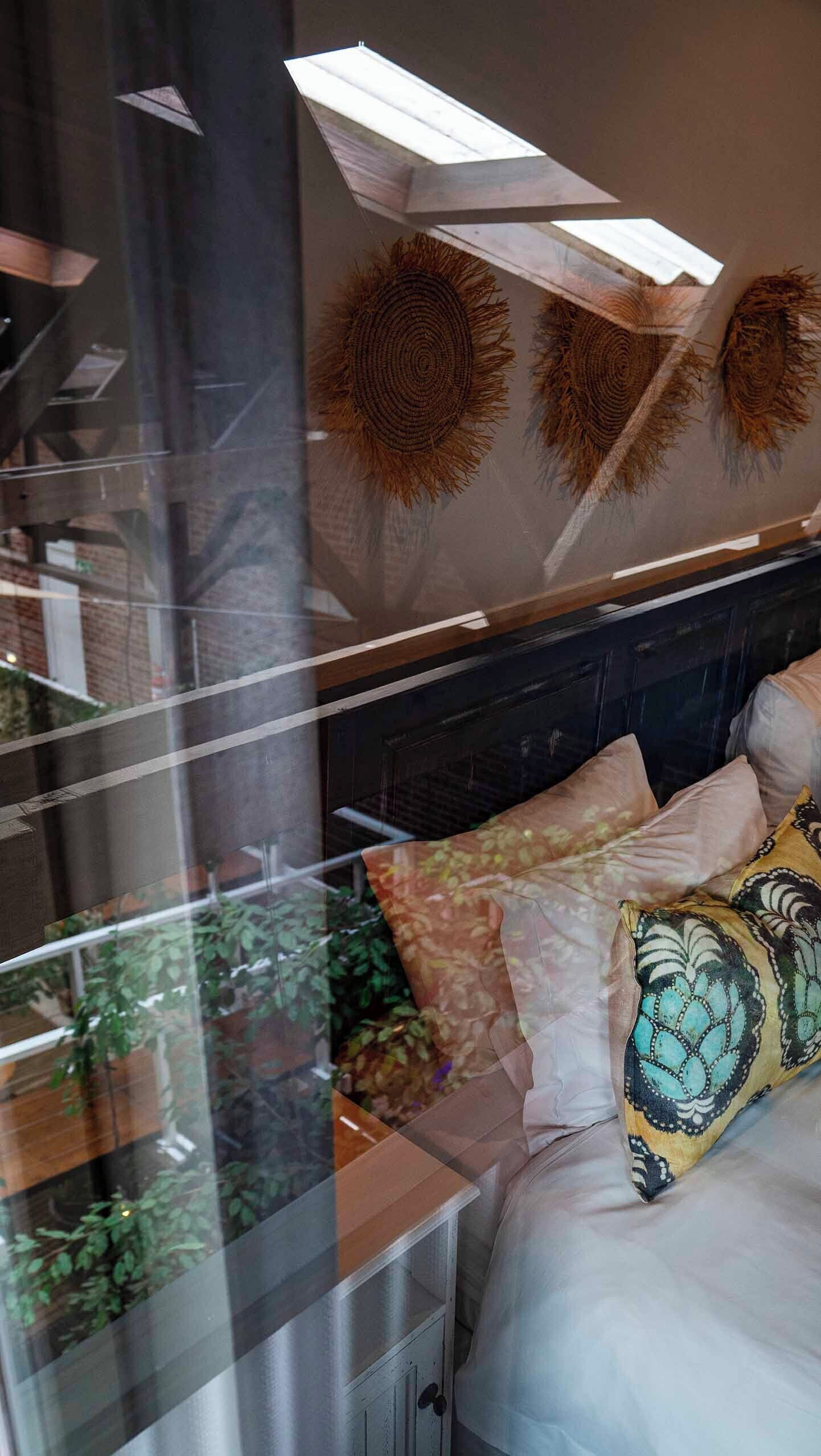A bedroom with a bed, pillows, a headboard, and wall decor.