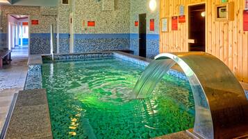 Una piscina techada, una piscina al aire libre de temporada, sombrillas