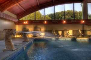 Una piscina techada, una piscina al aire libre de temporada, sombrillas