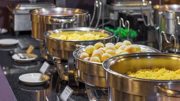 Buffet mit verschiedenen Speisen in Metallbehältern.