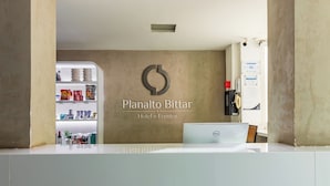 Una recepción con un cartel que dice 'Planalto Bittar Hotel e Eventos' y un refrigerador lleno de bocadillos.