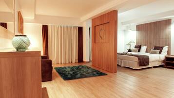 Ein modernes Schlafzimmer mit einem Holzschrank, einem Bett in Weißbraun und einem grünen Teppich auf Holzdielen.