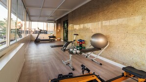 Un gimnasio con equipo de ejercicio, cinta de correr y máquina de remo.