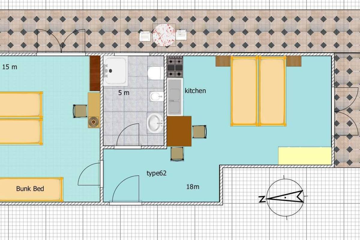 A floor plan of a hotel room with a bunk bed, a kitchenette, a bathroom, and a small sitting area.