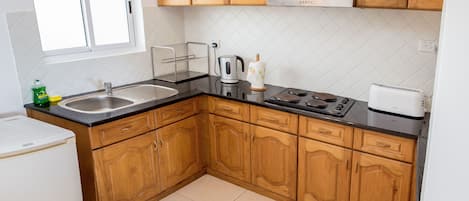 Una cucina con mobili in legno, un lavello, un fornello e un tostapane.