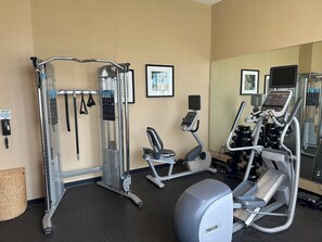 A gym with various exercise equipment, including a treadmill, elliptical, and weight machines. - Holiday Inn Hammond by IHG (Hammond)
