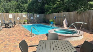 A backyard with a swimming pool, a hot tub, and a patio area with outdoor furniture. - Holiday Inn Hammond by IHG (Hammond)