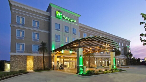 A Holiday Inn hotel with a covered entrance, multiple floors, and a stone facade. - Holiday Inn Hammond by IHG (Hammond)