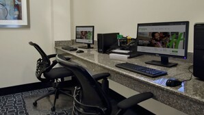 A workspace with two monitors, a keyboard, and a mouse on a granite countertop. - Holiday Inn Hammond by IHG (Hammond)