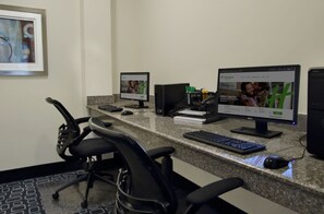 A workspace with two monitors, a keyboard, and a mouse on a granite countertop.