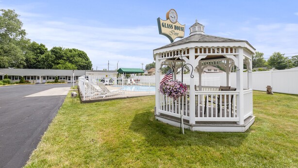 A gazebo-style structure with a sign reading "Glass House Inn" and an American flag.