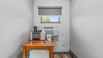 A compact kitchenette with a microwave, coffee maker, and a small refrigerator.