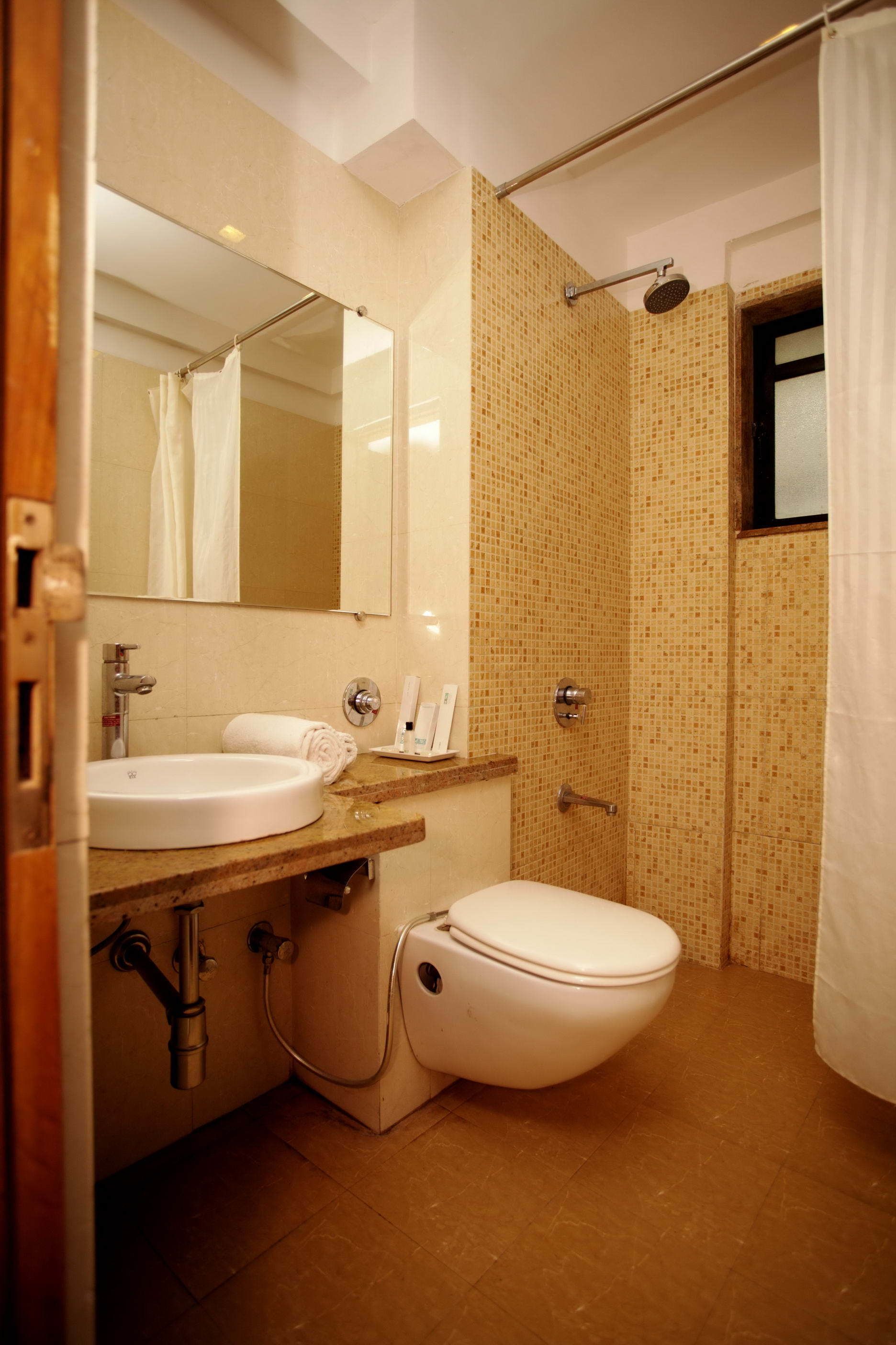 Une salle de bain avec un lavabo, des toilettes et une douche.