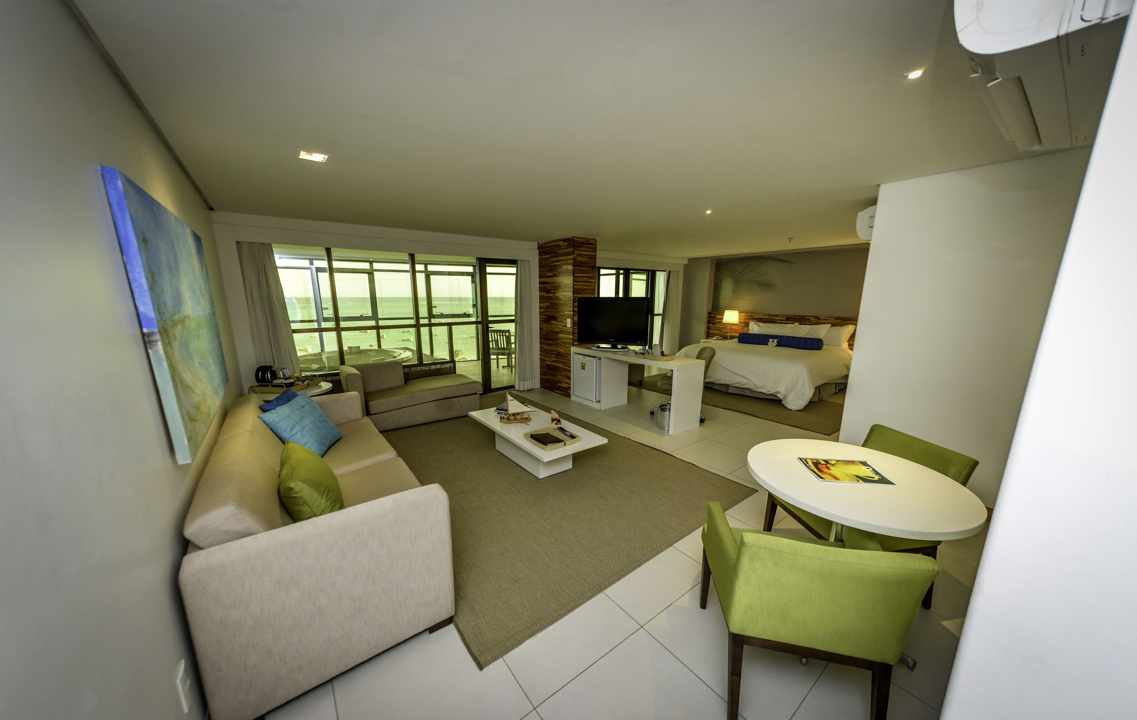 A modern living room with a sofa, coffee table, and a dining area with a table and chairs.