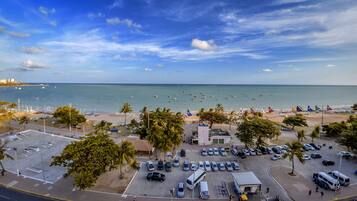 A coastal parking lot with a view of the beach and ocean.