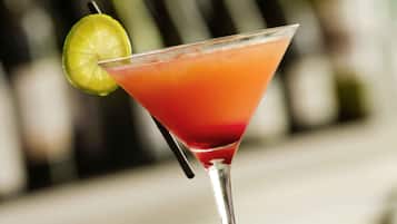 Un cóctel en una copa de martini, adornado con una rodaja de lima.