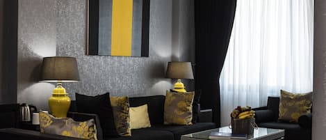 A modern living room with a sofa, two lamps, a coffee table, and a decorative wall piece.