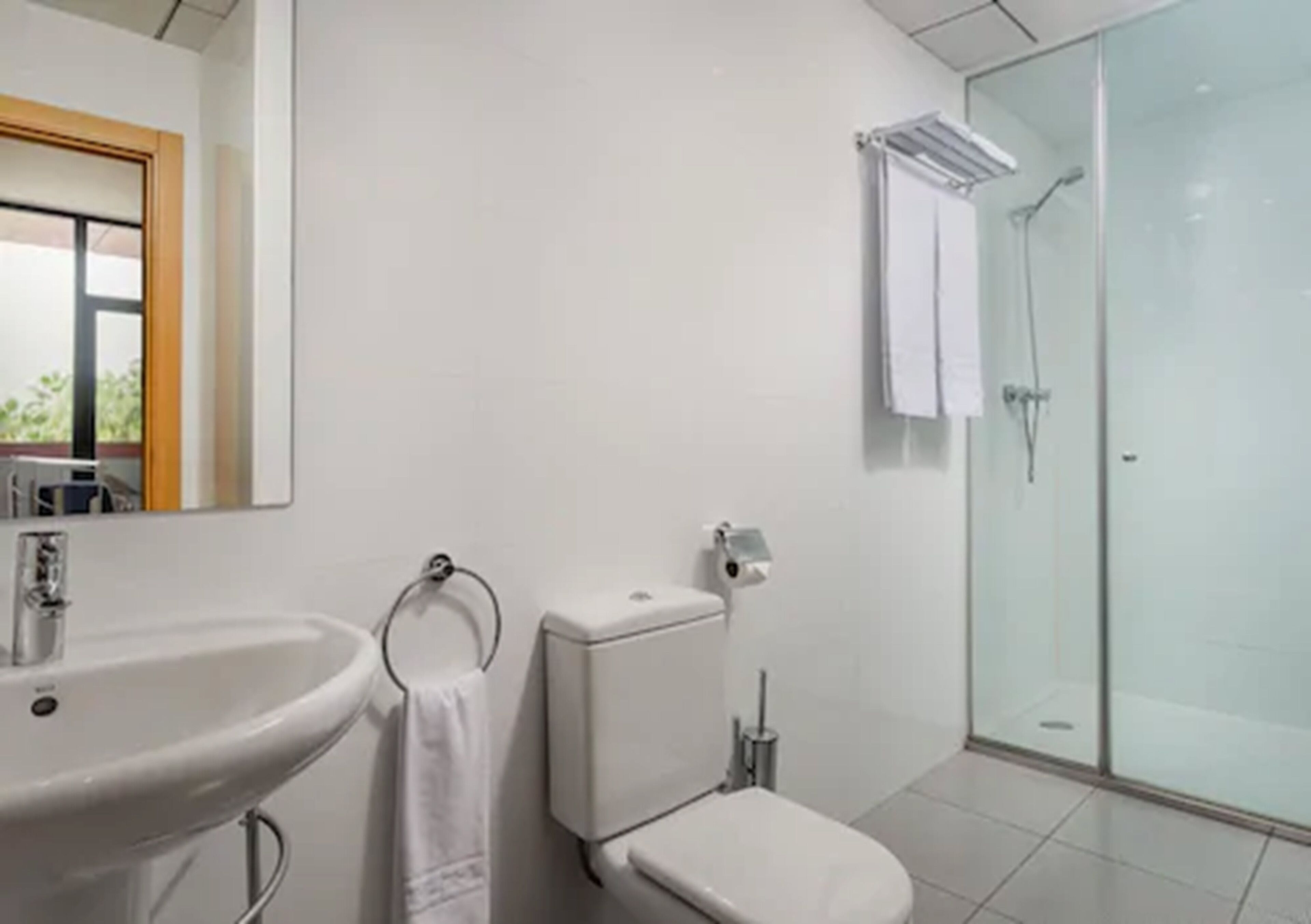 Une salle de bain moderne avec un lavabo, des toilettes et une douche à parois de verre.