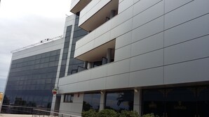 A modern building with a flat facade, large windows, and a sign for Murphy's. - Aparthotel Wellness (Paterna)