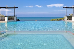 Una piscina al aire libre, sillones reclinables de piscina