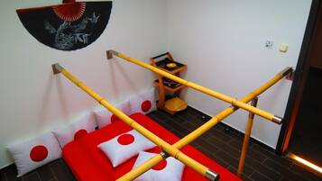 Simple, functional space with a single bed, wooden table, and decorative wall hanging.