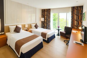 Une chambre d’hôtel avec deux lits, un bureau, une télévision et un balcon avec des rideaux.