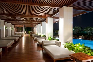 Una piscina al aire libre, sombrillas, sillones reclinables de piscina