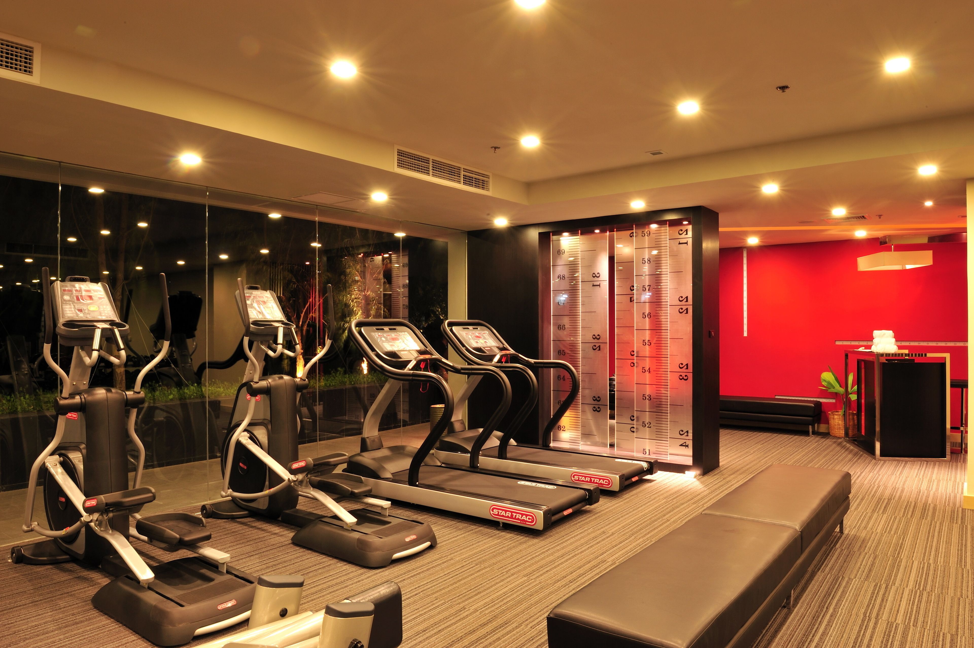 A gym with treadmills, elliptical machines, and a weight scale.