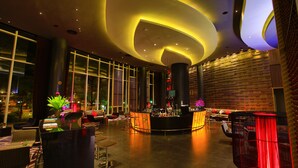 A modern lobby with a curved ceiling, a bar area, seating arrangements, and large windows. - Amaranth Suvarnabhumi Hotel - Free Suvarnabhumi Airport Shuttle (Bang Phli)