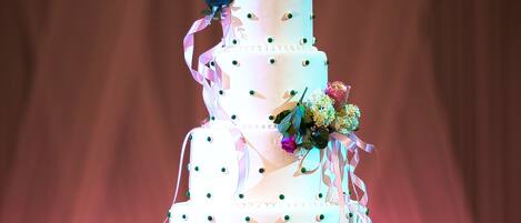 Un pastel de bodas de varios niveles con decoraciones florales y cintas.