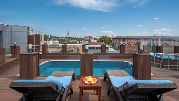 A rooftop pool area with lounge chairs and a table with a fruit platter. - Klas Hotel Istanbul Old City (Istanbul)