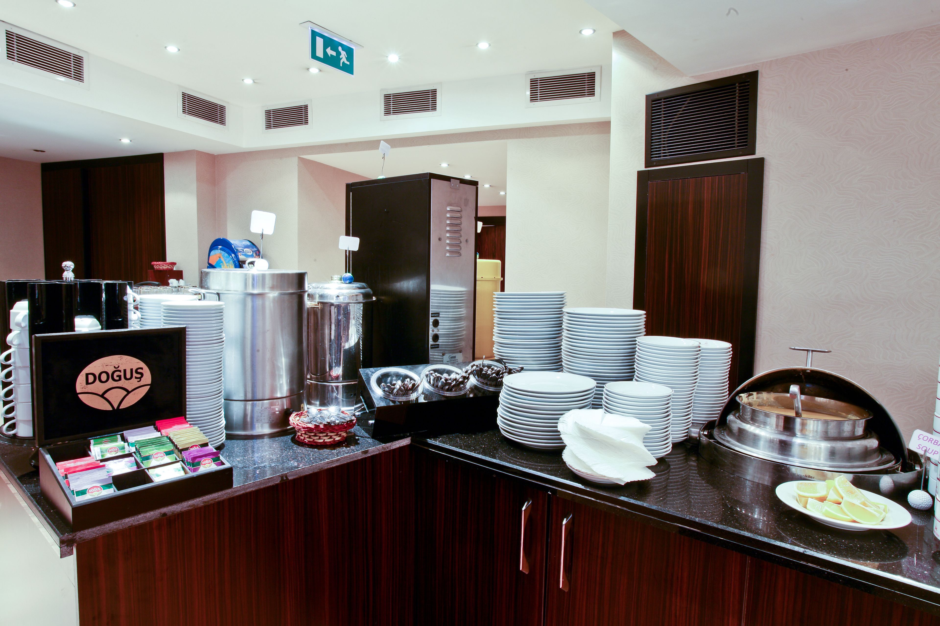 A buffet setup with various food items, a coffee station, and a sign for 'DOGUS'.