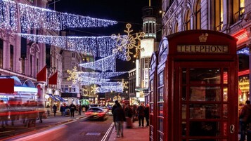 A street with a red telephone booth and a building with a sign that reads "TELEPHONE".