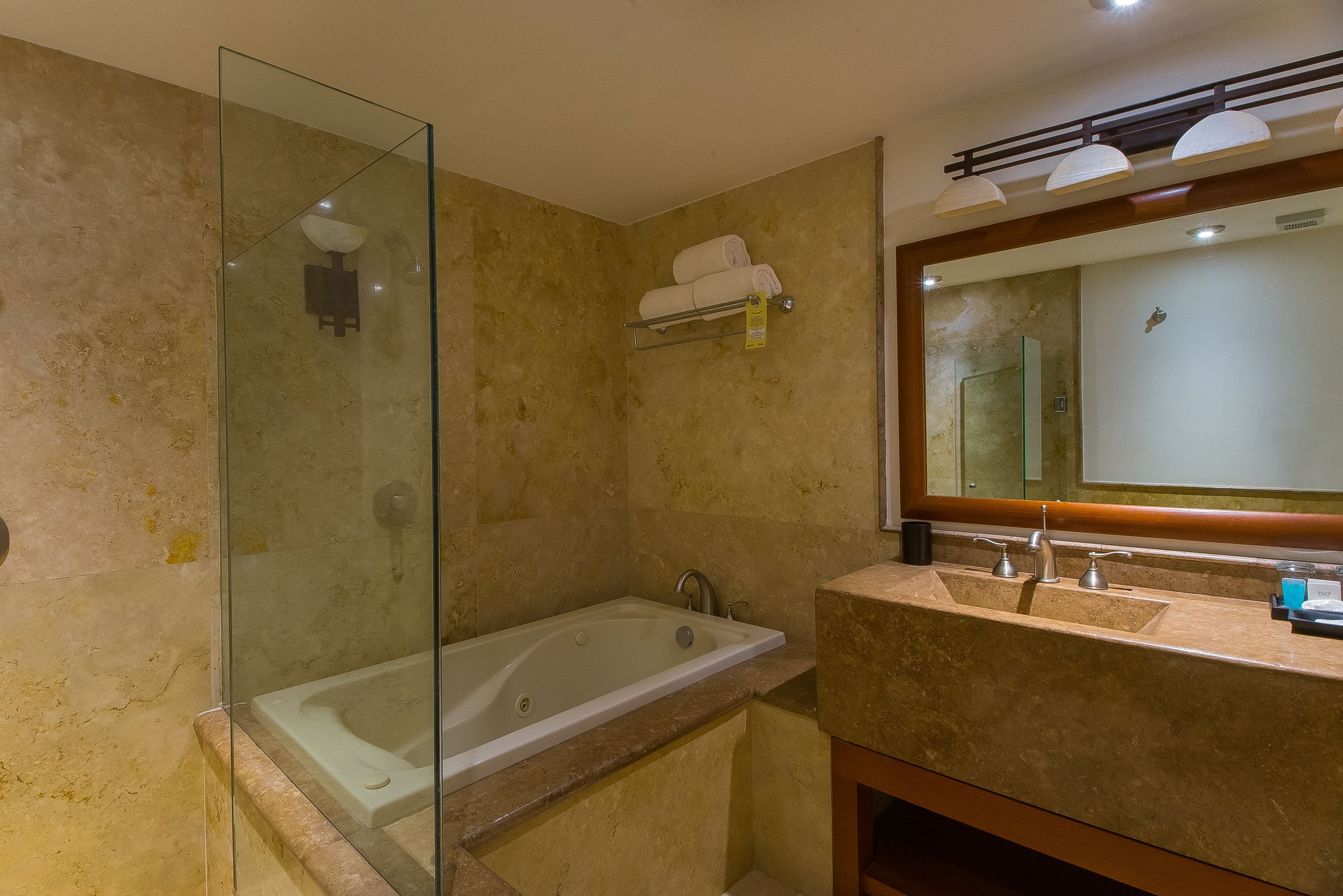 A modern bathroom with a glass-enclosed shower, a freestanding bathtub, and a vanity with dual sinks and a large mirror.