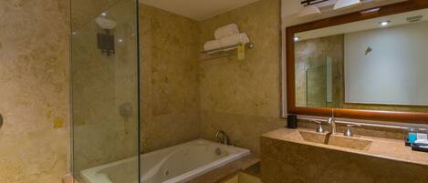 A modern bathroom with a glass-enclosed shower, a freestanding bathtub, and a vanity with dual sinks and a large mirror.