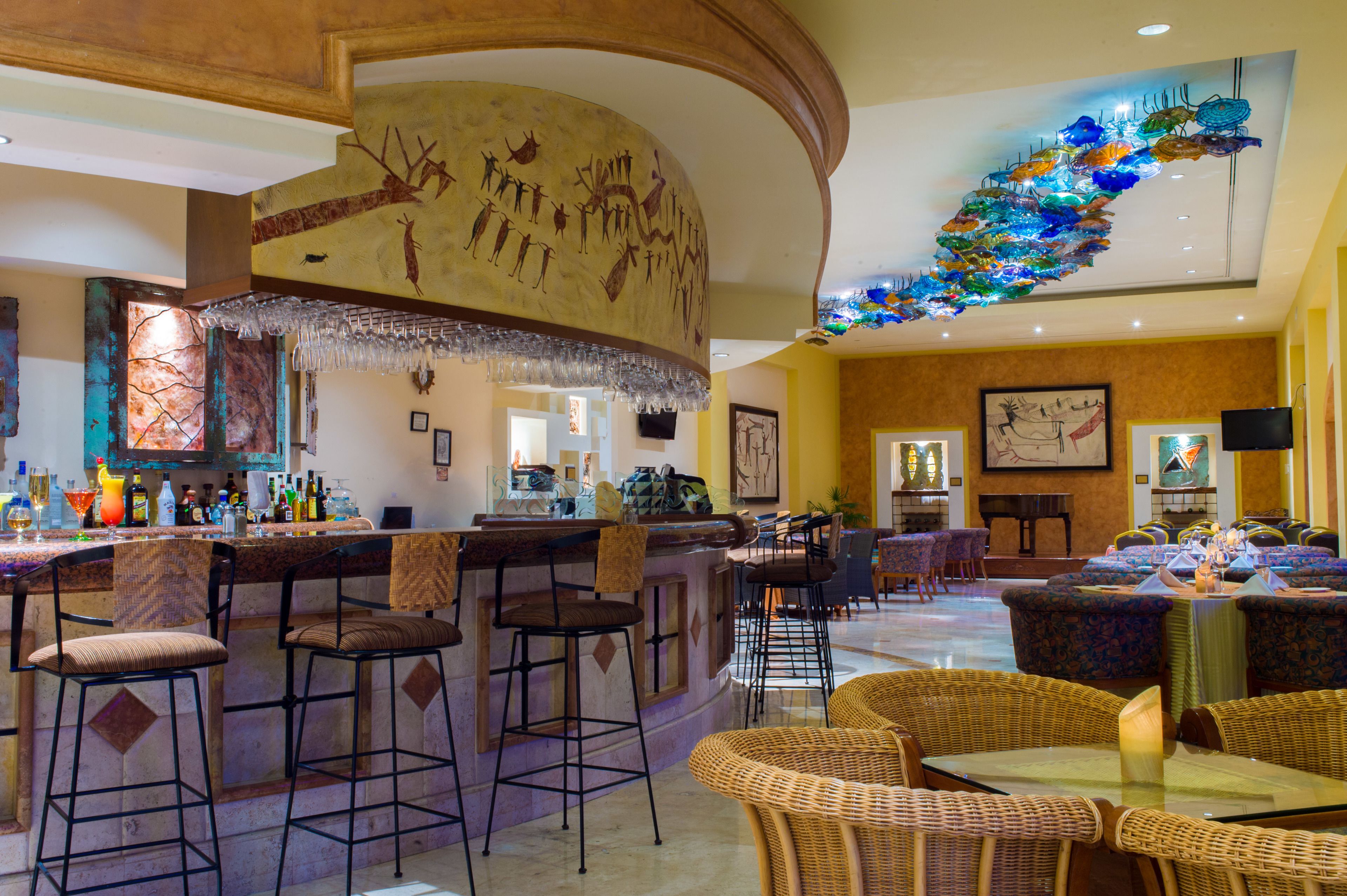 A bar area with stools, a counter, and a decorative ceiling.