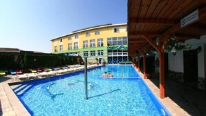A swimming pool with lounge chairs and a building in the background. - Hotel Seneca (Baia Mare)