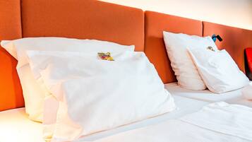 Ropa de cama hipoalergénica y caja de seguridad en la habitación