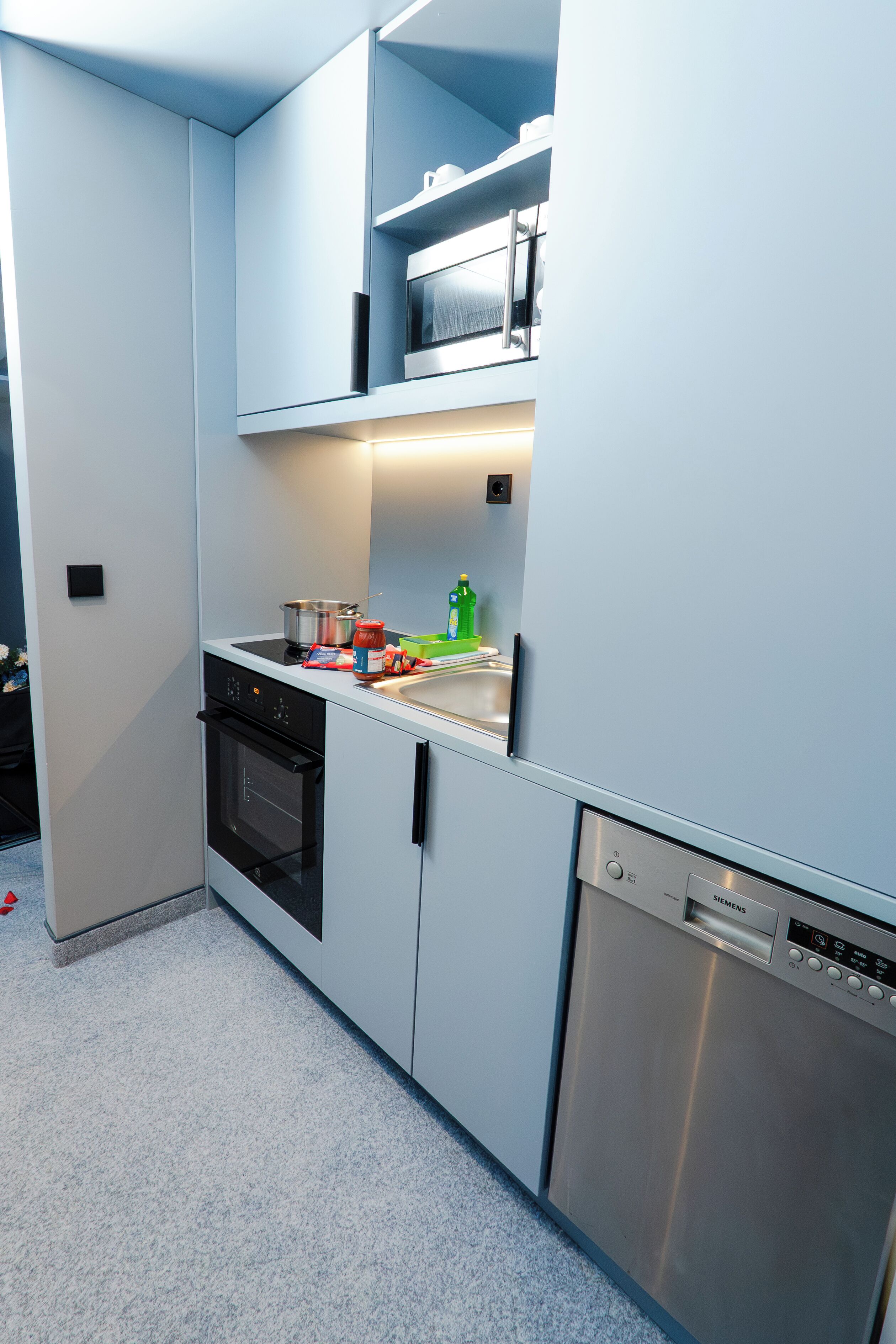 A modern kitchen with a dishwasher, oven, and microwave.